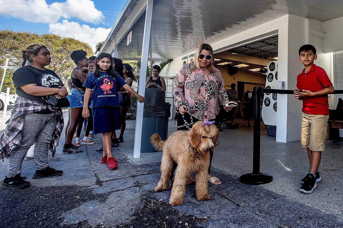 Owner of the Sweet Haven Books store in Cauley Square, Patty Medina with her dog Honey, on Feb. 24, 2023, line up to buy milkshakes, made with fresh fruits, at Knaus Berry Farm in Homestead, a business owned and operated by the Knaus family since 1956.