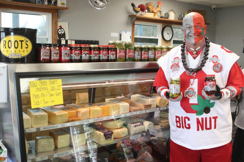 Fremont's Jon Paul Peters, alias "The Big Nut," shows off some of his barbecue sauces, sweet and dill pickles for sale at Root's Poultry. Big Nut products are now sold at nearly three dozen stores in Northwest Ohio, with proceeds supporting the Big Nut Scholarship Foundation for Ohio State University students.