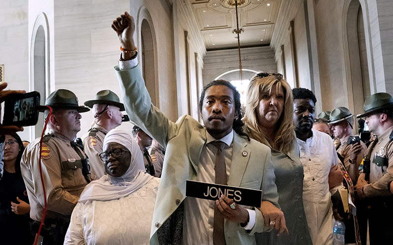 Rep. Justin Jones (D-Nashville) raises his fist as he is escorted back to the Tennessee House chamber
