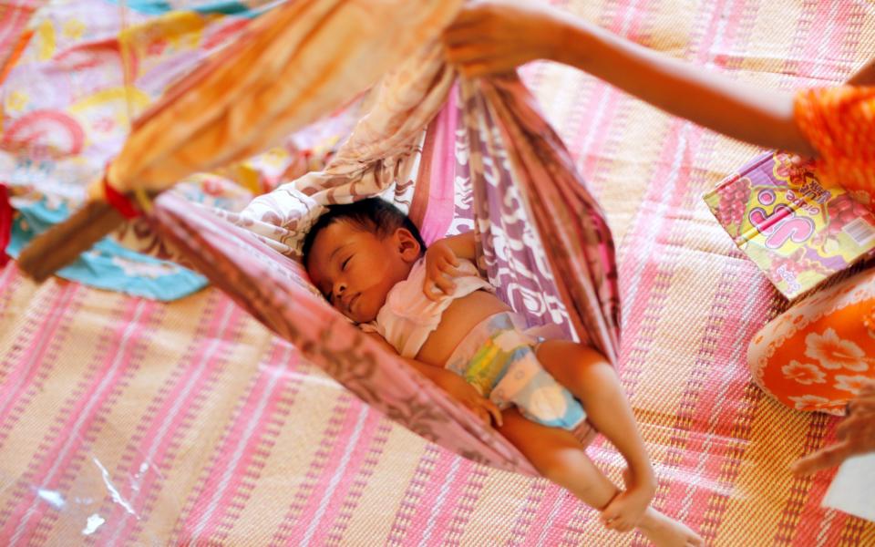 A baby slepps inside a tent at an evacuation center outside Marawi - Credit: REUTERS/Jorge Silva