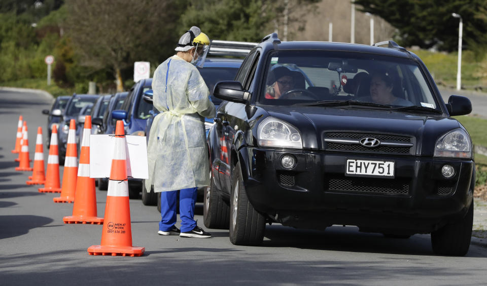 Medical staff prepare take a COVID-19 test from a visitor to a drive through community based assessment centre in Christchurch, New Zealand, Thursday, Aug. 13, 2020. Health authorities in New Zealand are scrambling to trace the source of a new outbreak of the coronavirus as the nation's largest city, Auckland, goes back into lockdown. (AP Photo/Mark Baker)