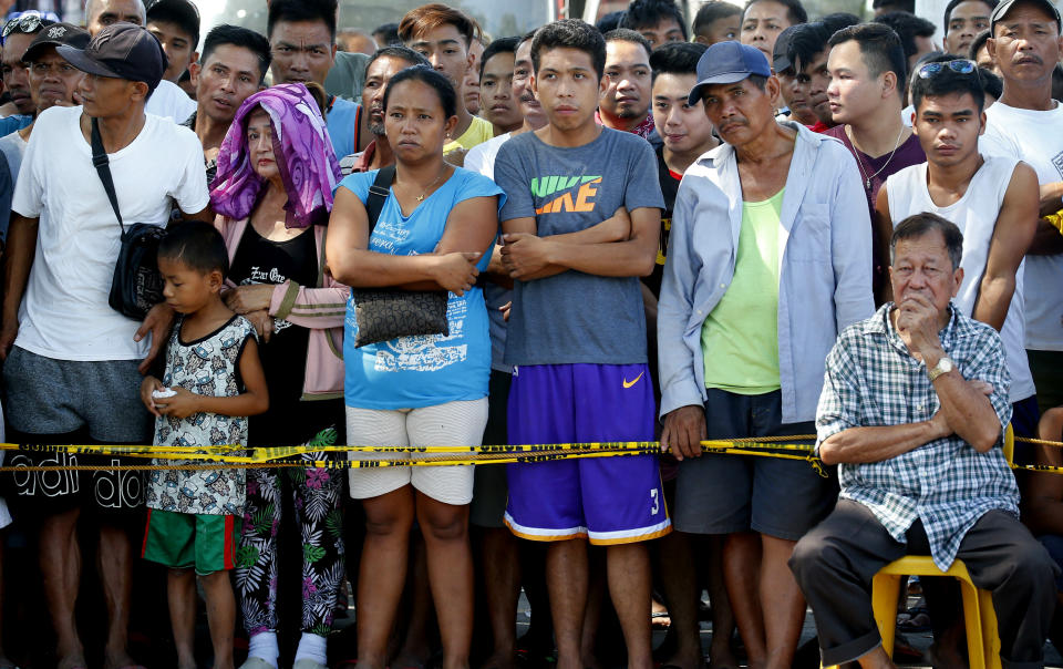 Residents watch as rescuers continue to search for survivors following Monday's 6.1 magnitude earthquake that caused the collapse of a commercial building in Porac township, Pampanga province, north of Manila, Philippines, Tuesday, April 23, 2019. The strong earthquake struck the northern Philippines Monday trapping some people in a collapsed building, damaged an airport terminal and knocked out power in at least one province, officials said. (AP Photo/Bullit Marquez)