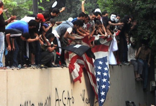 Egyptian protesters tear down the US flag at the US embassy in Cairo on September 11. The American ambassador to Libya, J. Christopher Stevens, and three officials were killed when a mob attacked the US consulate in the eastern city of Benghazi, the interior ministry said Wednesday, just hours after Islamists also stormed Washington's embassy in Cairo