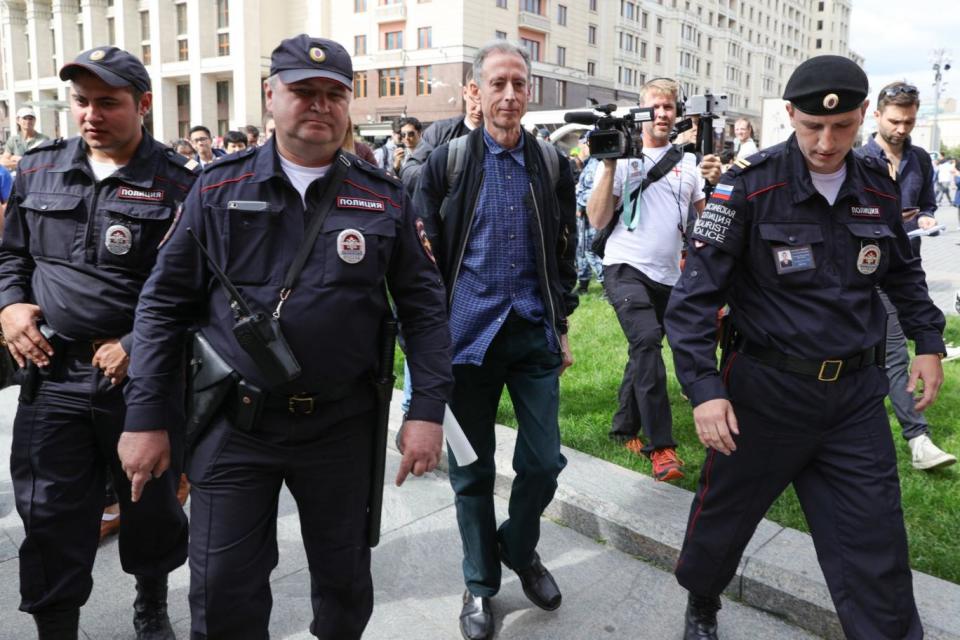 Peter Tatchell is led away by police in Moscow (PA)