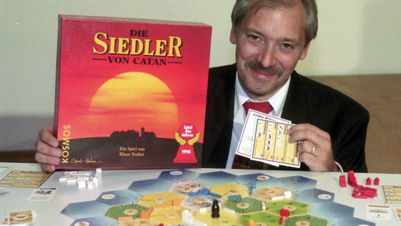 Klaus Teuber, a dental technician from Darmstadt, presents his game “The Settlers of Catan,” Friday, Sept. 29, 1995, in Frankfurt, Germany. Teuber, creator of the hugely popular Catan board game in which players compete to build settlements on a fictional island, died on April 1, 2023 after a short and serious illness, according to a family statement. He was 70.