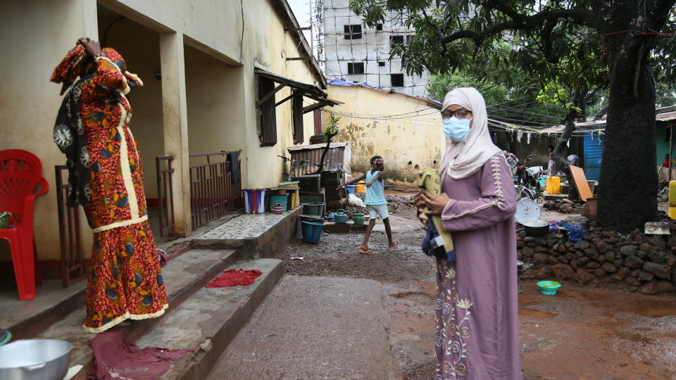 Guinean wrestler Fatoumata Yarie Camara, right, gets ready to go to pray at the mosque in Conakry, Guinea, Tuesday July 20, 2021. A West African wrestler's dream of competing in the Olympics has come down to a plane ticket. Fatoumata Yarie Camara is the only Guinean athlete to qualify for these Games. She was ready for Tokyo, but confusion over travel reigned for weeks. The 25-year-old and her family can't afford it. Guinean officials promised a ticket, but at the last minute announced a withdrawal from the Olympics over COVID-19 concerns. Under international pressure, Guinea reversed its decision. (AP Photo/Youssouf Bah)