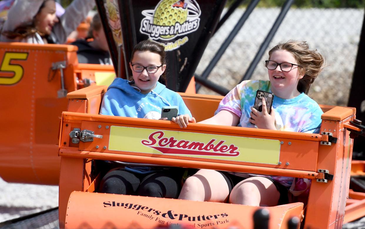 Students Kyleigh Coughlin, left, and Kylie Brown hold tight riding the Scrambler as Massillon City School fifth grade students enjoy an end of the year field trip to Sluggers & Putters Amusement Park in Canal Fulton.