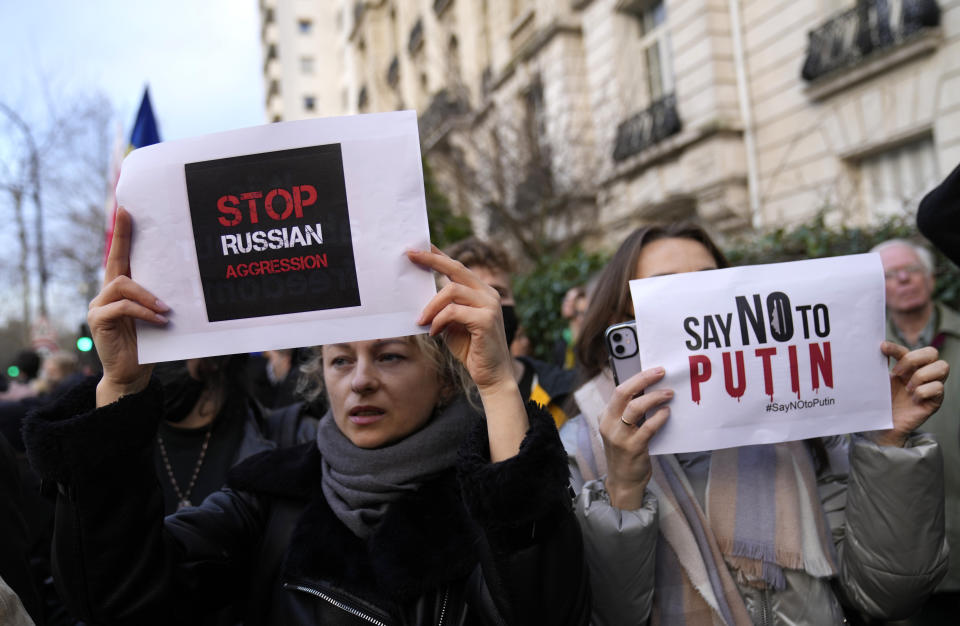 Two protestors hold signs in support of Ukraine during a demonstration in front of the Russian embassy in Paris, France, Tuesday, Feb. 22, 2022. World leaders are getting over the shock of Russian President Vladimir Putin ordering his forces into separatist regions of Ukraine and they are focusing on producing as forceful a reaction as possible. Germany made the first big move Tuesday and took steps to halt the process of certifying the Nord Stream 2 gas pipeline from Russia. (AP Photo/Francois Mori)