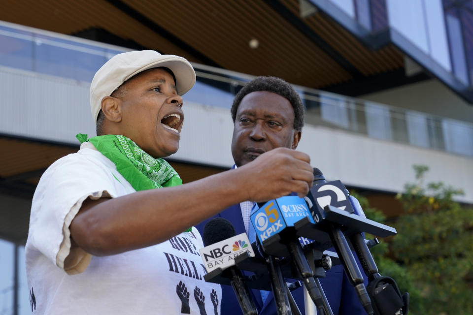 Kareim McKnight, left, talks to reporters during a press conference outside Chase Center, announcing the filing of a federal civil rights lawsuit against the San Francisco Fire and Police Departments in San Francisco, Wednesday, Aug. 10, 2022. McKnight alleges a paramedic, under the orders of a police sergeant, injected her with a sedative while she was handcuffed after protesting the Supreme Court's Roe v. Wade decision during a Golden State Warriors championship game. (AP Photo/Godofredo A. Vásquez)
