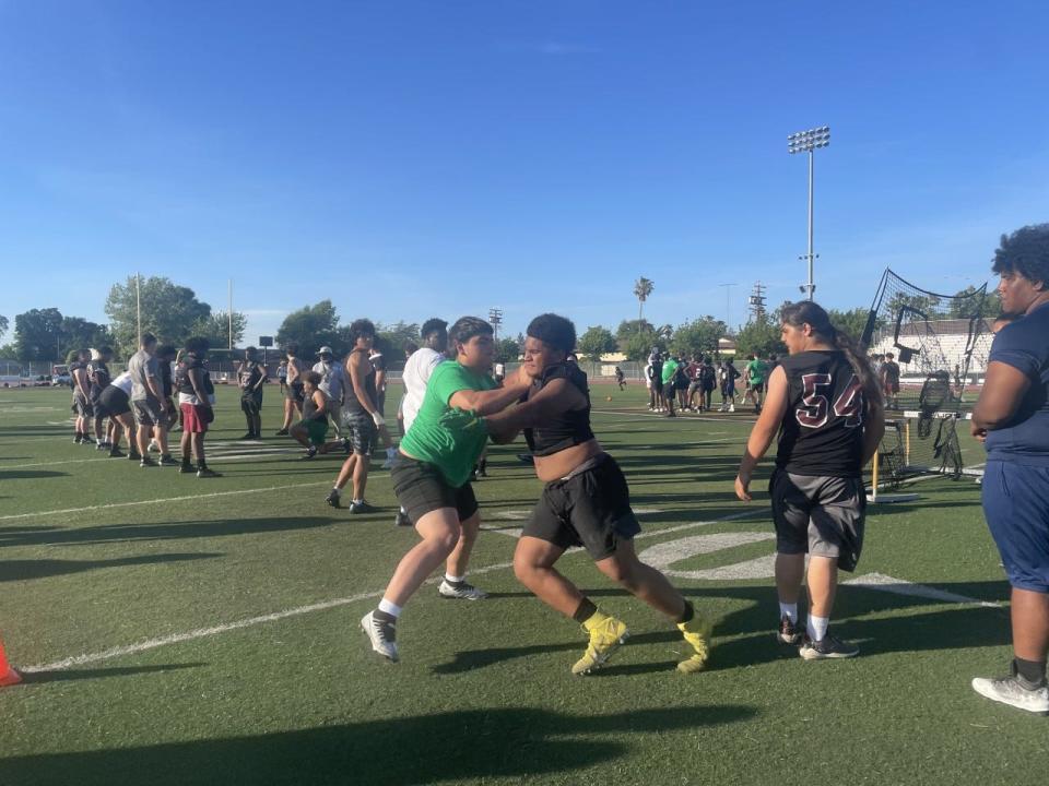 A St. Mary's football player and a Weston Ranch football player do a tackling drill during the Stagg High School Football Showcase on May 17.