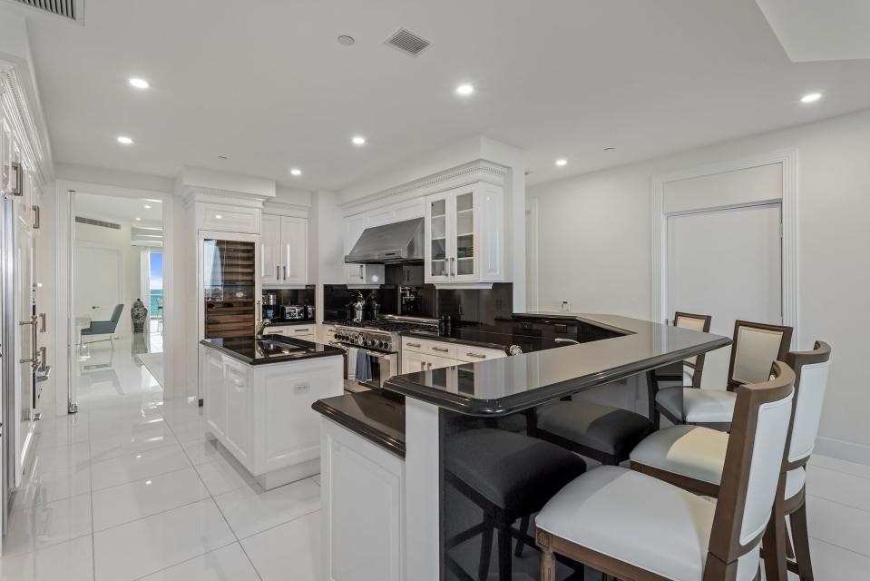 “For a wine connoisseur, we have an entire floor-to-ceiling wine cabinet as part of the kitchen,” says condominium owner Carol Vance. The door at the rear leads into the dining area.