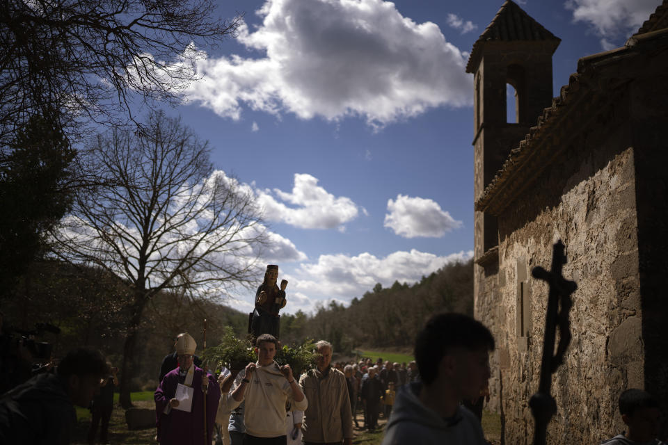 Local residents take part in a procession carrying a statue of the Our Lady of the Torrents, a virgin historically associated with drought, in l'Espunyola, north of Barcelona, Spain, Sunday, March 26, 2023. Farmers and parishioners gathered Sunday at the small hermitage of l'Espunyola, a rural village in Catalonia, to attend a mass asking the local virgin Our Lady of the Torrents for rain. Prayers and hymns were offered to ask for divine intervention in solving the earthly crisis. (AP Photo/Emilio Morenatti)