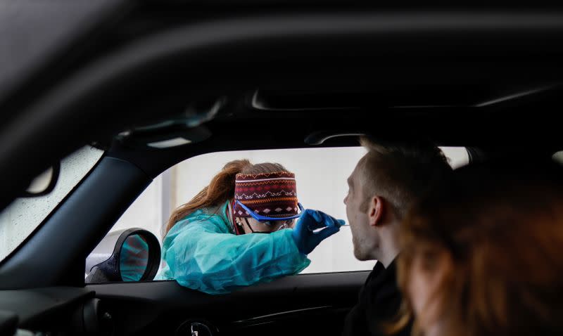 A woman takes a saliva sample of a man at a rapid coronavirus disease (COVID-19) test centre amid the COVID-19 pandemic in Furstenfeldbruck