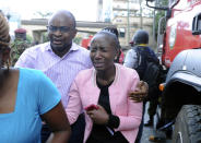 A woman cries as she is rescued from the scene at a hotel complex in Nairobi, Kenya Tuesday, Jan. 15, 2019. Terrorists attacked an upscale hotel complex in Kenya's capital Tuesday, sending people fleeing in panic as explosions and heavy gunfire reverberated through the neighborhood. (AP Photo/John Muchucha))