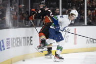 Vancouver Canucks right wing Vasily Podkolzin (92) checks Anaheim Ducks defenseman Kevin Shattenkirk (22) during the second period of an NHL hockey game in Anaheim, Calif., Sunday, March 19, 2023. (AP Photo/Kyusung Gong)