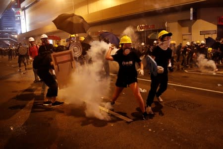 Anti-extradition demonstrators throw back tear gas, after a march to call for democratic reforms in Hong Kong