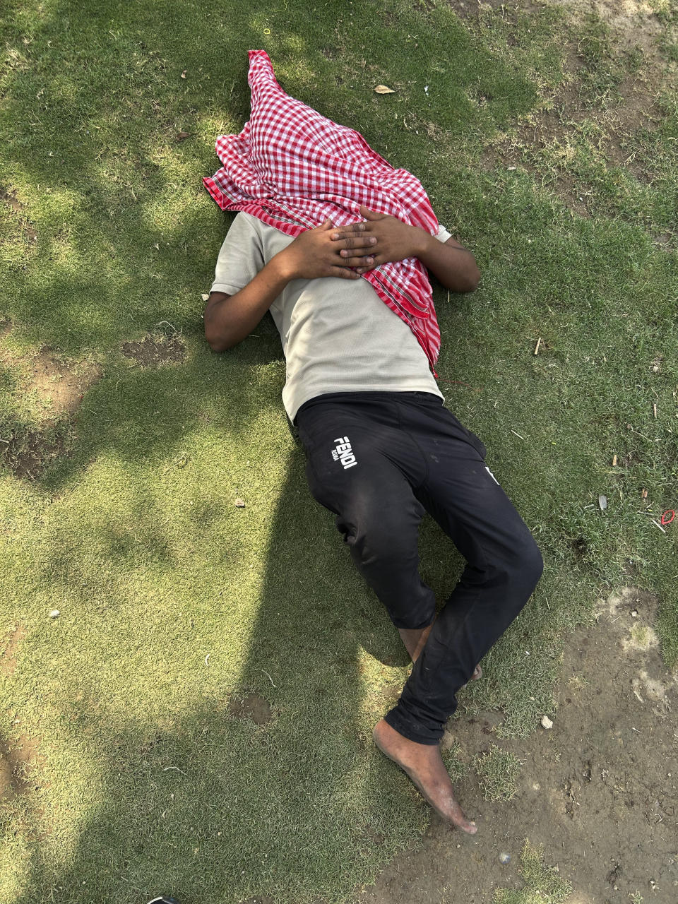 A man sleeps under the shade of a tree in a public park in New Delhi, India, Saturday, May 18, 2024. Swathes of northwest India sweltered under scorching temperatures on Saturday, with the capital New Delhi under a severe weather alert as extreme temperatures strike parts of the country. (AP Photo/Shonal Ganguly)