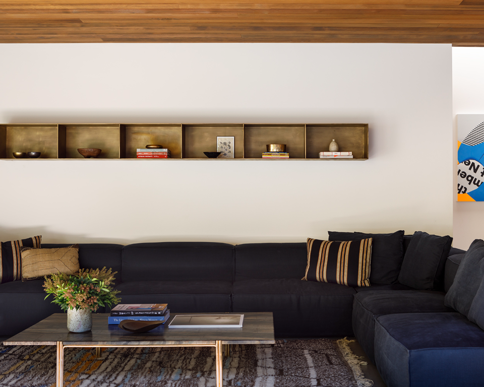 Modern living room with blue floating open shelving and large couch