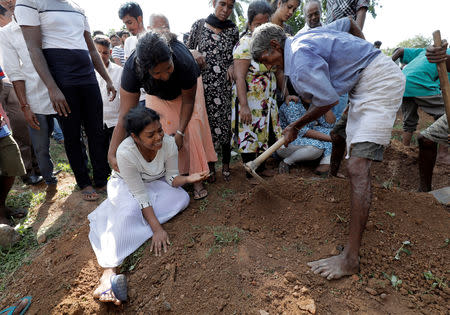 A woman reacts during a mass burial of victims, two days after a string of suicide bomb attacks on churches and luxury hotels across the island on Easter Sunday, in Colombo, Sri Lanka April 23, 2019. REUTERS/Dinuka Liyanawatte