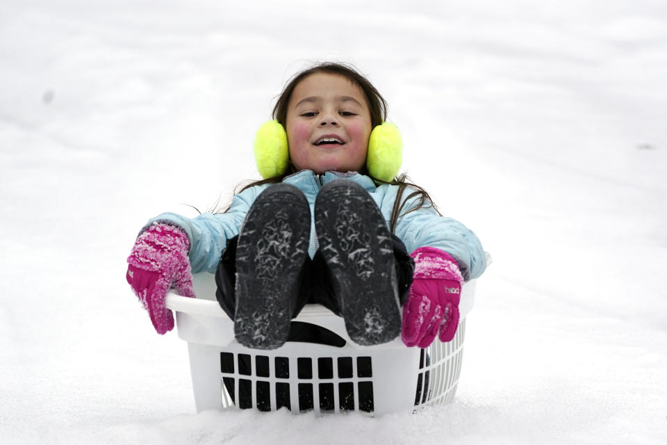 Peyton McKinney uses a laundry basket for a sled Monday, Feb. 15, 2021, in Nolensville, Tenn. Much of Tennessee was hit with a winter storm that brought freezing rain, snow, sleet and freezing temperatures. (AP Photo/Mark Humphrey)