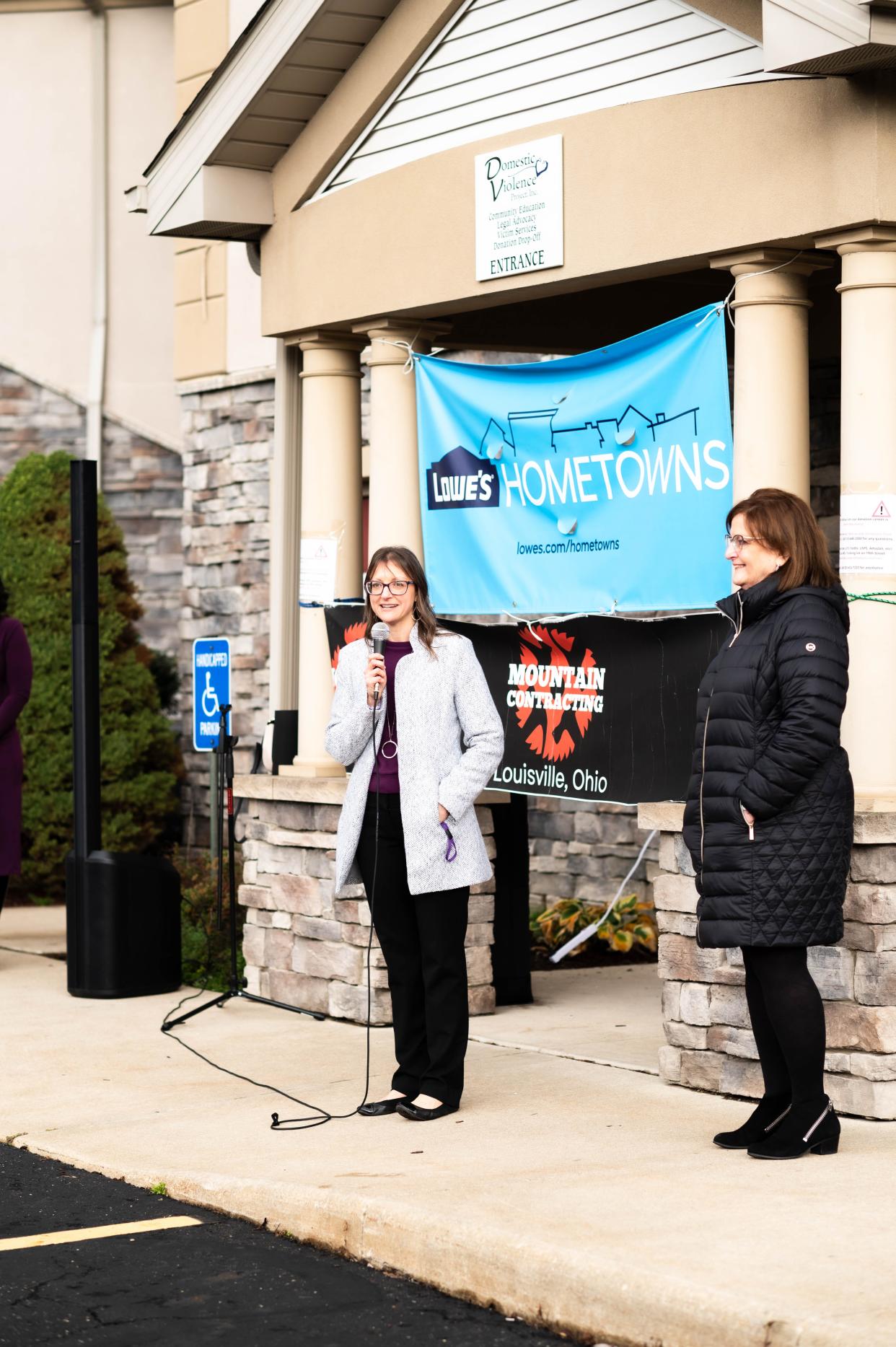 Julie Donant, executive director of the Domestic Violence Project, speaks at its recent open house to dedicate newly renovated space through a partnership with Lowe's. Looking on is Randi Smuckler, the agency's board president.