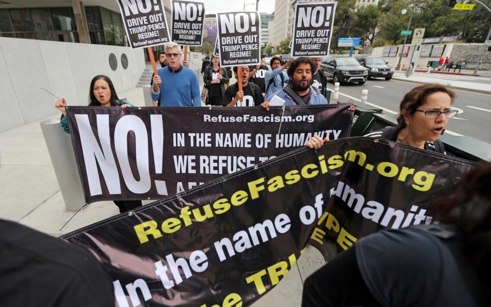 People chant as they protest at Comey's firing outside the downtown Los Angeles federal building - Credit: AP