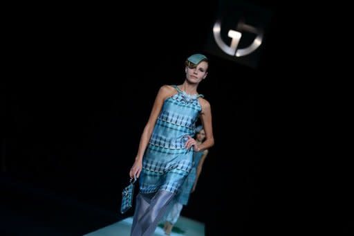 Models walk the ruway at the Giorgio Armani show on September 23 during Milan fashion week. The key to the collection was light -- shimmering on silk or bouncing off crystal adornments or rhinestone-studded heels