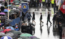 The family of 2013 Boston Marathon bombing victim Martin Richard, from left, mother Denise, brother Henry, and father Bill Richard walk onto Boylston street for the raising of the flag during a tribute on the one year anniversary of the Boston Marathon bombings, Tuesday, April 15, 2014 in Boston. (AP Photo/Charles Krupa)