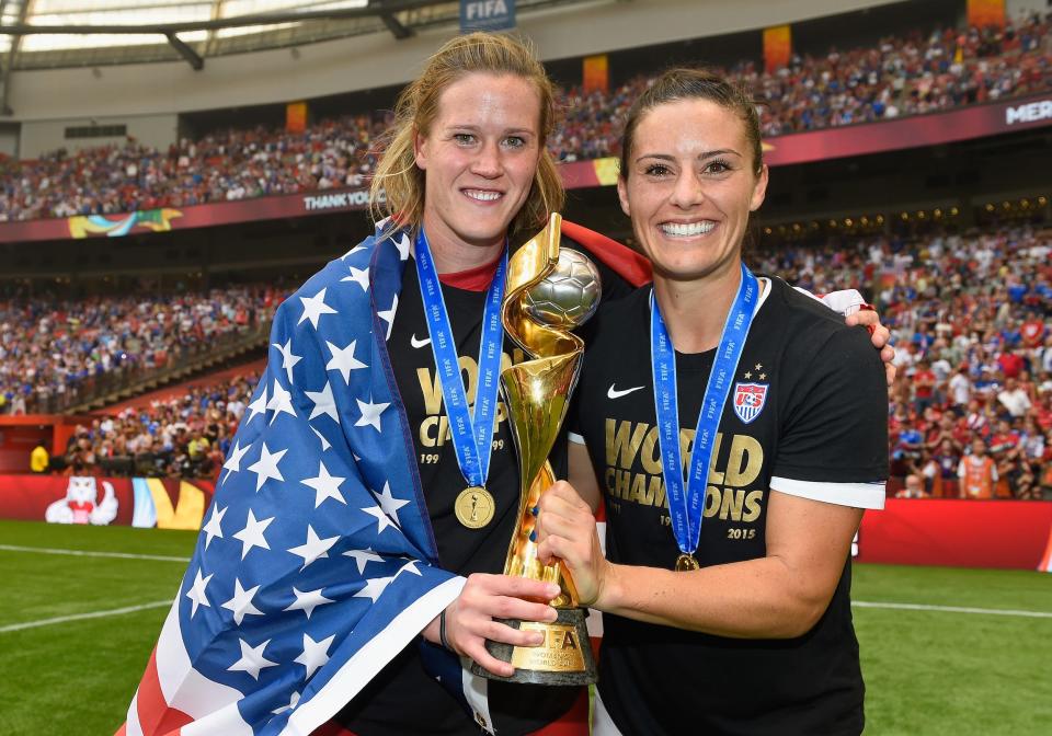 Ali Krieger (right) and goalkeeper Alyssa Naeher pose with the 2015 World Cup trophy.