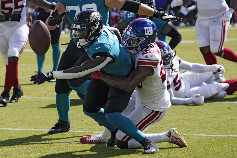 Jacksonville Jaguars running back Travis Etienne Jr. (1) fumbles when he gets hit by New York Giants safety Xavier McKinney (29) during the first half of an NFL football game Sunday, Oct. 23, 2022, in Jacksonville, Fla. (AP Photo/John Raoux)