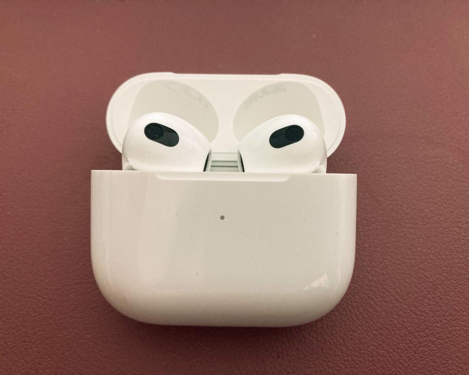 Apple Airpods (3rd Gen) in charging case against dark pink background