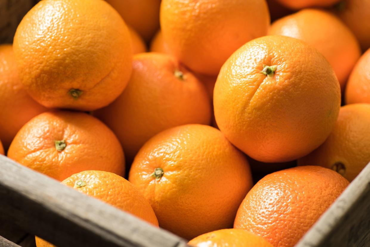 Navel Oranges in a wooden crate.