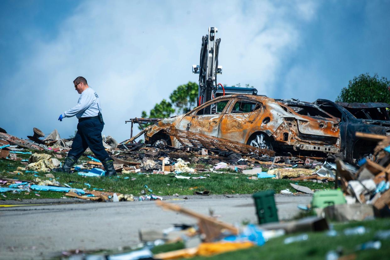 An investigator walks through the debris from a home explosion which occurred the day before on Rustic Ridge Drive in Plum, Pa., on Sunday.