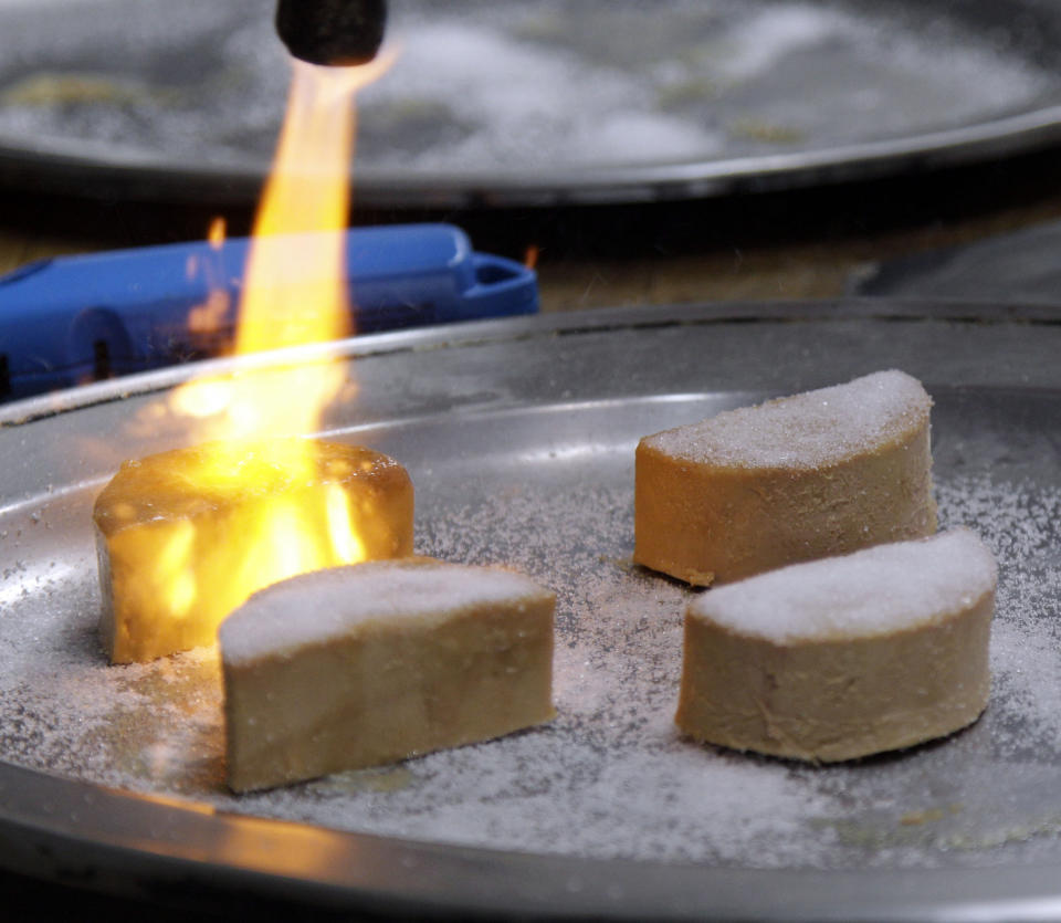 FILE - In this Friday, May 11, 2012, file photo, Foie Gras is torched and made into a Brulee at the Sent Sovi restaurant in Saratoga, Calif. Foie gras is back on the menu in California after a judge ruled the rich dish can't be prevented from being brought in from out of state. California's ban on the delicacy, the fattened liver of a duck or goose, was challenged by out-of-state producers. An appeals court upheld the ban, but on Tuesday, July 14, 2020, a judge ruled for the plaintiffs, including farmers in Canada and New York. (AP Photo/Marcio Jose Sanchez, File)