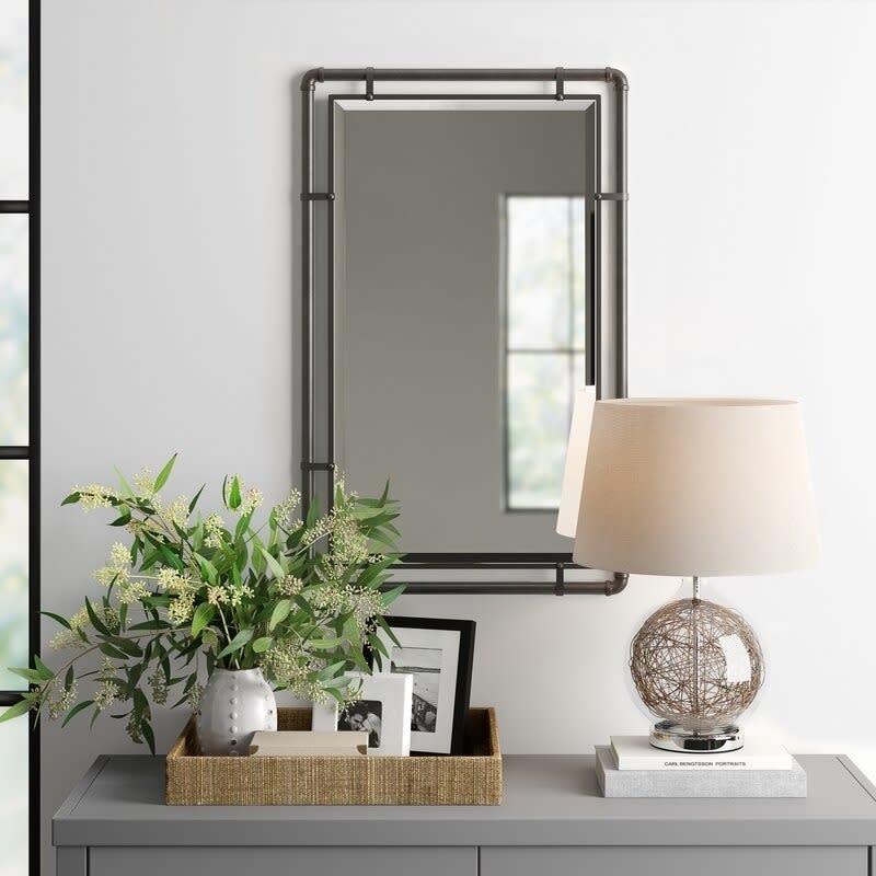 Square mirror on wall above living room table