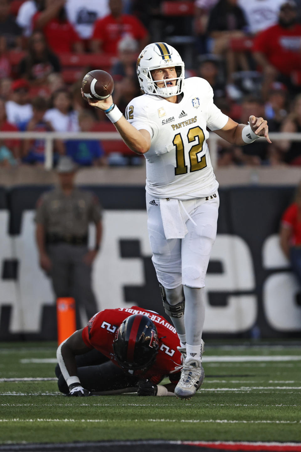 Florida International's Max Bortenschlager (12) throws away the ball while being tackled by Texas Tech's Brandon Bouyer-Randle (2) during the first half of an NCAA college football game on Saturday, Sept. 18, 2021, in Lubbock, Texas. (AP Photo/Brad Tollefson)