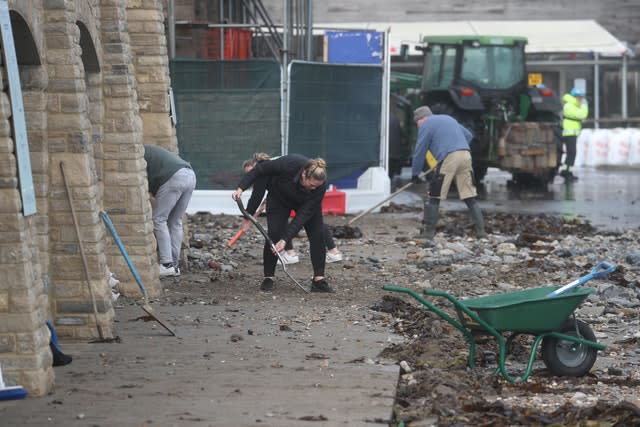 People clean up stones brought in by the sea in Swanage 