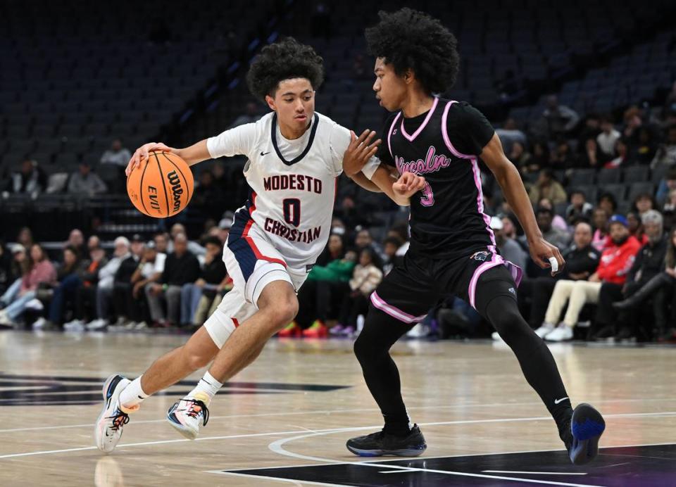 Modesto Christian’s Myles Jones moves the ball as Lincoln’s Elijah Homes defends in the Sac-Joaquin Section Division I championship game at the Golden 1 Center in Sacramento, Calif., Wednesday, Feb. 21, 2024.