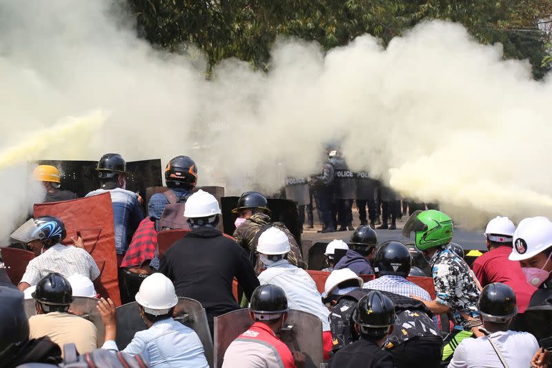 Tear gas and fire extinguisher gas float around demonstrators during a protest against the military coup in Naypyitaw