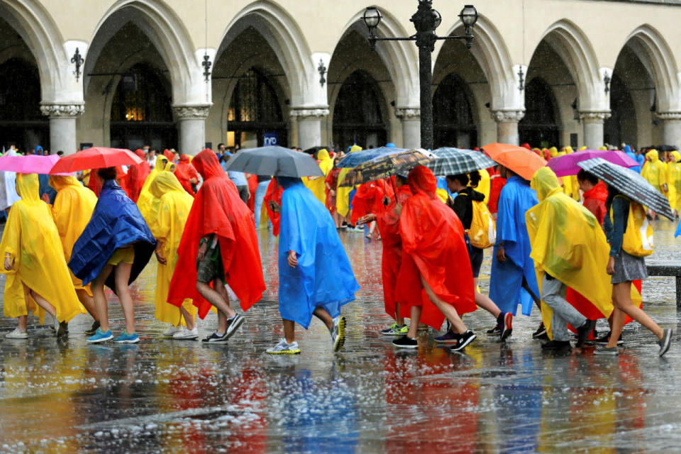 <p>Pilgrims covered in rain coats play during heavy rain on World Youth Day at the Main Square in Krakow, Poland July 26, 2016. (Agencja Gazeta/Mateusz Skwarczek/via REUTERS)</p>