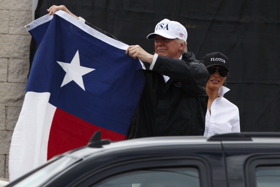 President Trump holds the flag of Texas aloft during a visit to the devastation of Hurricane Harvey (Picture: REX Features)