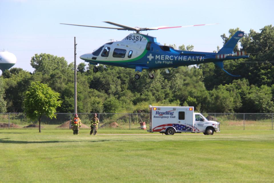 An air ambulance from St. Vincent's Hospital in Toledo, Ohio prepares to land in a park close to Baw Beese Lake while firefighters and paramedics standby.