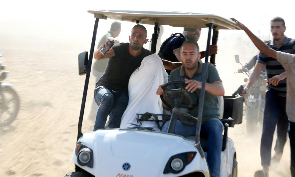 Palestinians transporting a captured Israeli civilian from the Kfar Aza kibbutz into Gaza on Saturday.