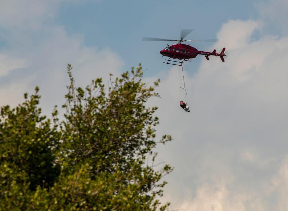 An aerial ignition device hangs from a helicopter used to ignite a prescribed burn in areas dangerous and otherwise difficult to reach by crews on foot on Thomas Mountain in Mountain Center, Calif., Friday, June 16, 2023. 