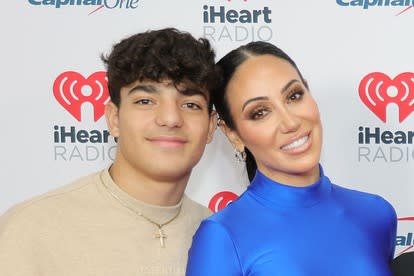 Melissa Gorga and Gino Gorga posing together in front of a step and repeat.