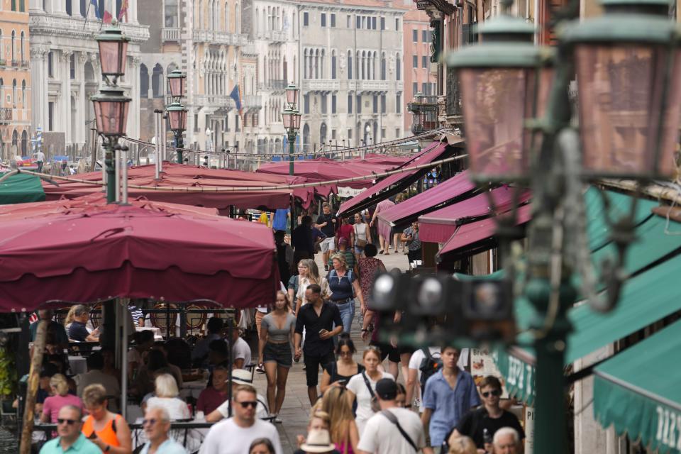 Tourists walk down a crowded street in Venice, Italy, Wednesday, Sept. 13, 2023. The Italian city of Venice has been struggling to manage an onslaught of tourists in the budget travel era. The stakes for the fragile lagoon city are high this week as a UNESCO committee decides whether to insert Venice on its list of endangered sites. (AP Photo/Luca Bruno)