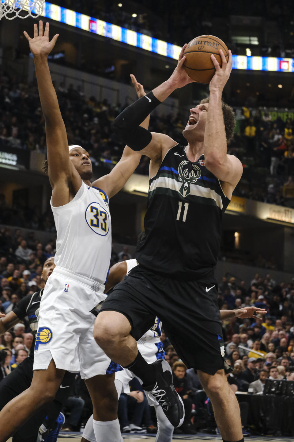 Milwaukee Bucks center Brook Lopez (11) shoots next to Indiana Pacers center Myles Turner (33) during the second half of an NBA basketball game in Indianapolis, Wednesday, Feb. 12, 2020. The Pacers won 118-111. (AP Photo/AJ Mast)