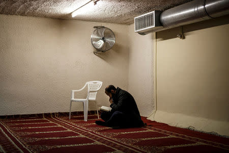 A Muslim living in Greece reads the Koran before Friday prayers at the Masjid Al-Salam makeshift mosque in Athens, Greece, February 3, 2017. REUTERS/Alkis Konstantinidis