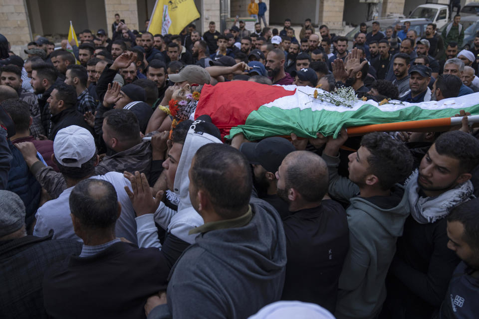 Palestinian mourners carry the body of Daoud Mahmoud Khalil Rayan, 42, during his funeral in the West Bank village of Beit Duqqu, southwest of Ramallah, Thursday, Nov. 3, 2022. The Palestinian Health Ministry said that Rayan was killed by Israeli fire in the occupied West Bank. Israeli police said it happened during a raid in the territory and alleged Rayan threw a firebomb at their forces. (AP Photo/Nasser Nasser)