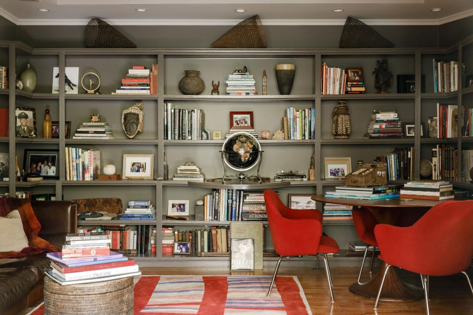 The family’s library has floor-to-ceiling shelves stocked with mementos from Lisa and Everick’s many travels. The midcentury executive chairs and ebony-wood tulip table are both by Eero Saarinen, paired with a leather tuxedo sofa from Roche Bobois Paris. Underneath it all is another Classic Rug Collection custom wool-and-silk rug.